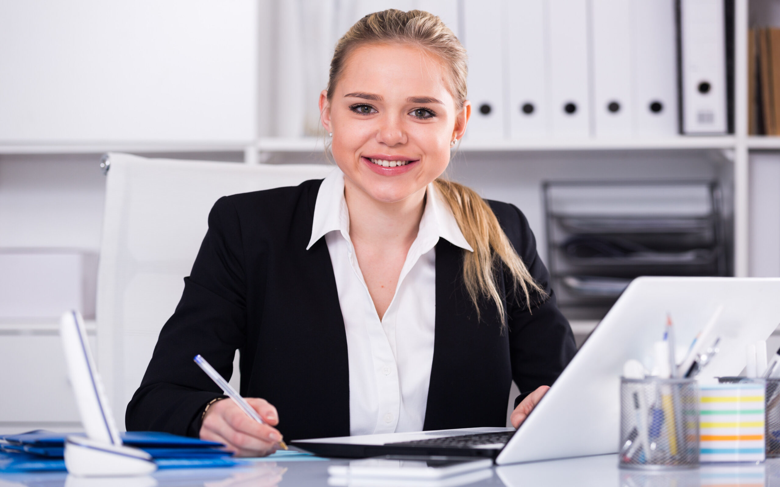 Successful businesswoman using laptop at workplace
